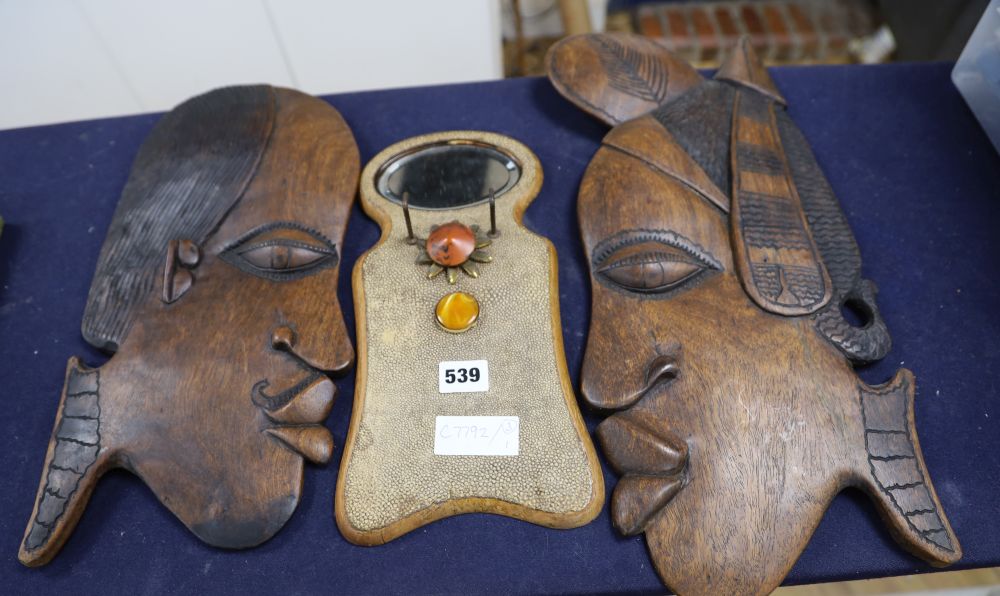 Two carved wooden face masks and a shagreen mirror